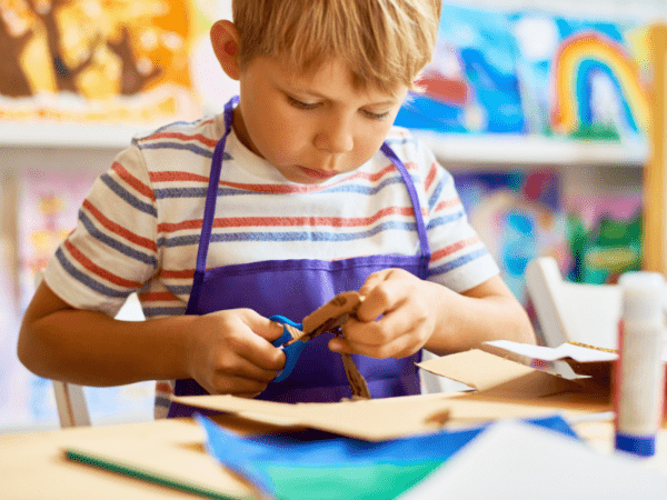 Little boy cutting paper and doing crafts