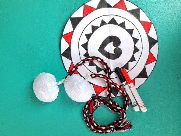 Image of poi and maori paper craft against a teal background