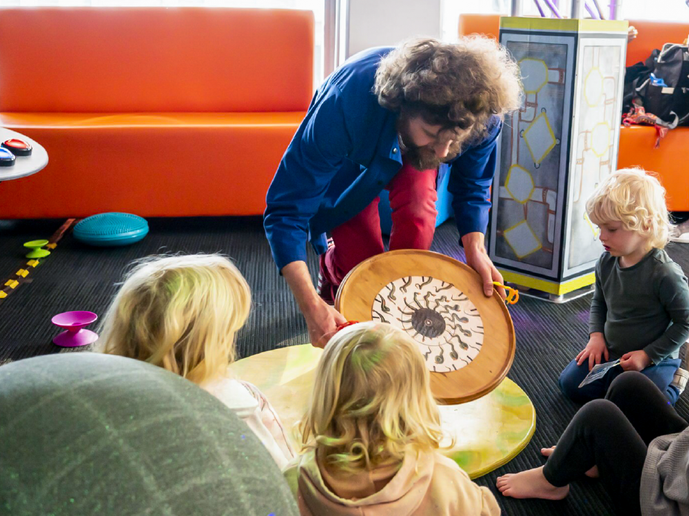 Tom from Science Jam shows children an spinning disk
