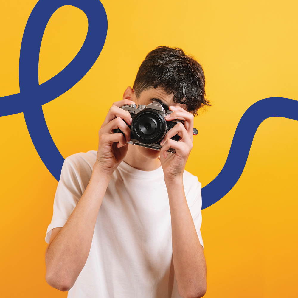 A young photographer holds a camera