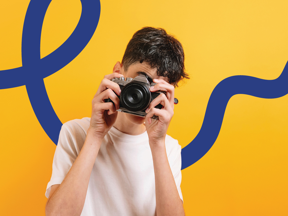 A young photographer holds a camera