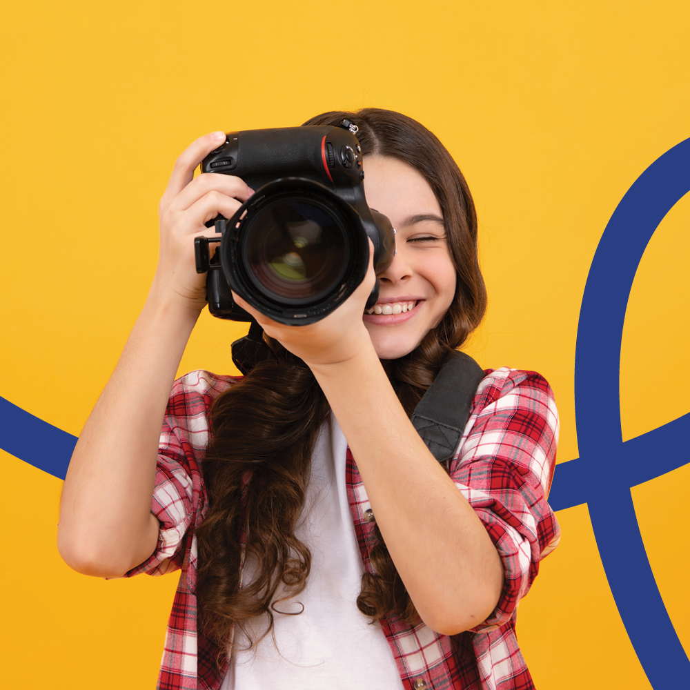 A young photographer holds a camera