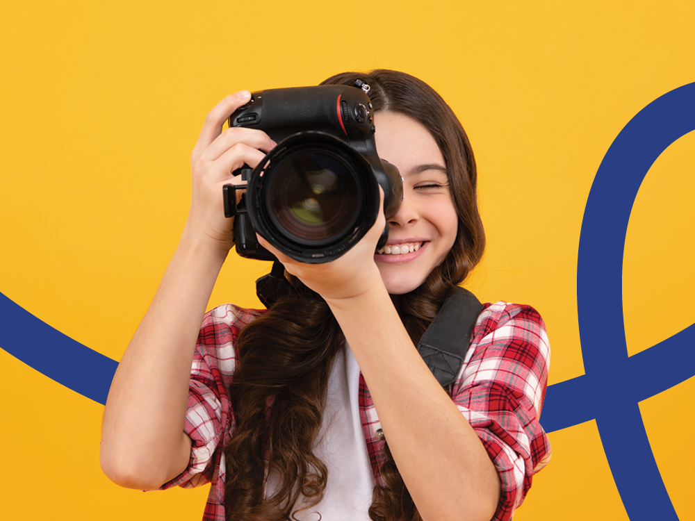 A young photographer holds a camera