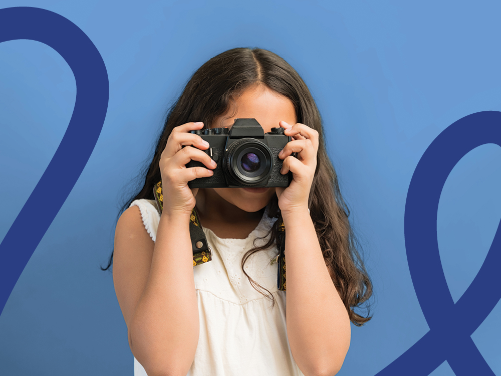 A young photographer holds a camera